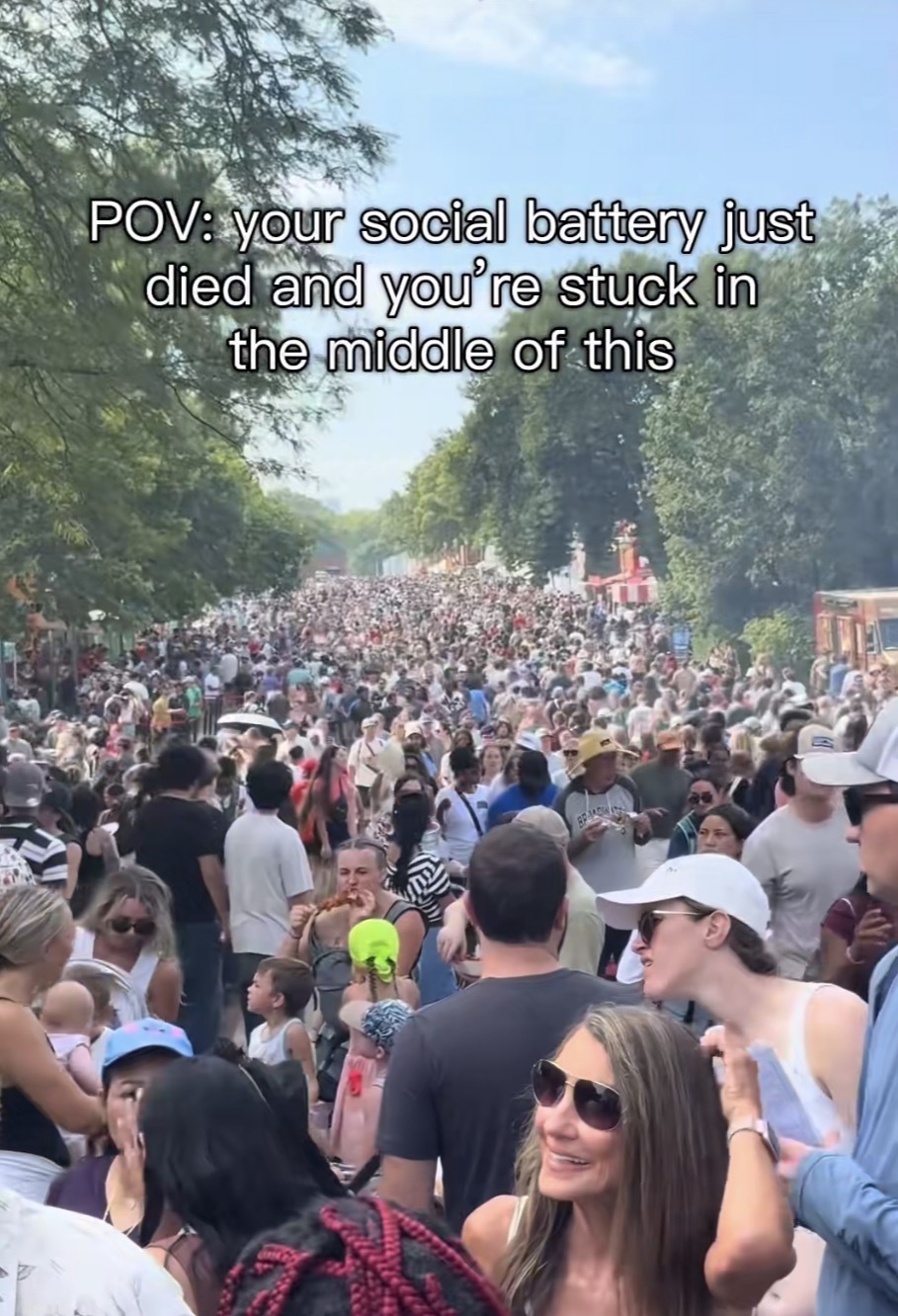 Photo taken within a very large crowd outside with the caption, “POV: your social battery just died and you're stuck in the middle of this“
